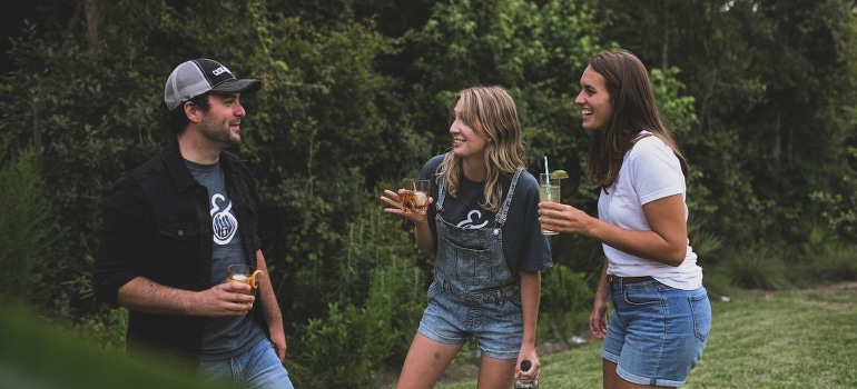 Friends standing and talking about ways to meet your new neighbors after moving to Margate