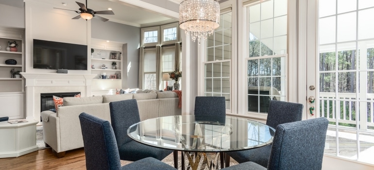 Glass-top table and gray chairs- an apartment that the person found before the move to Parkland FL