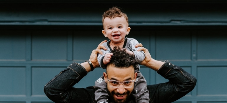 A man carrying his baby son after the move to Parkland FL