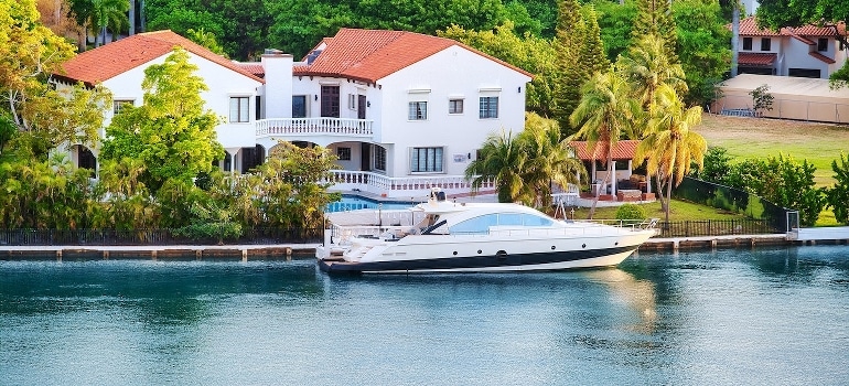 A white house with a brown roof near the water