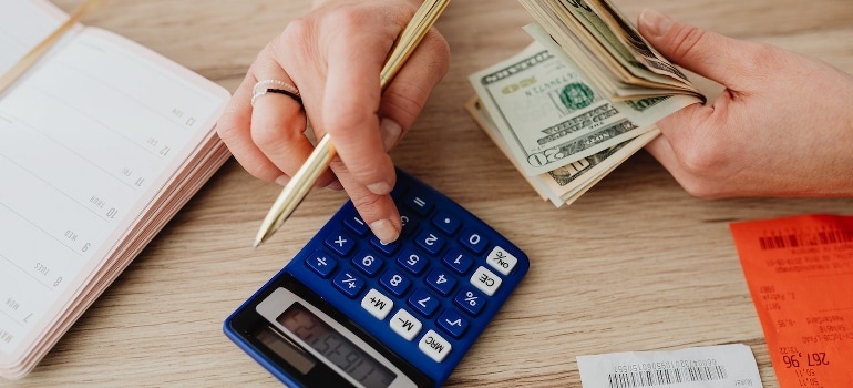 A person calculates money by using a calculator before relocating from Weston to Miami.