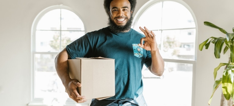 One of the experts for moving from Miami to Los Angeles holding a cardboard box