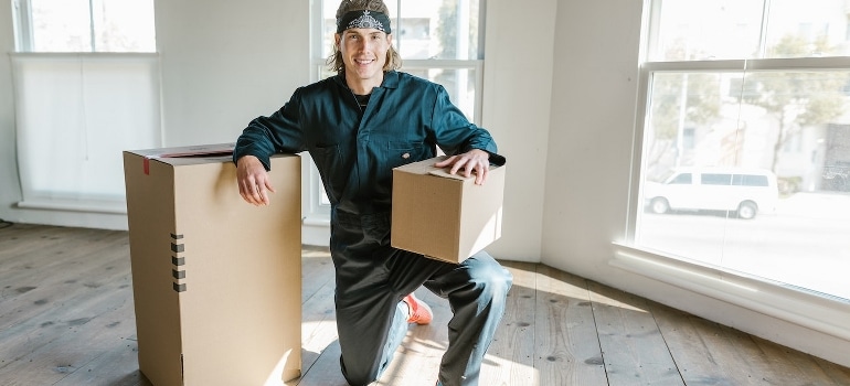 Professional mover posing between cardboard boxes