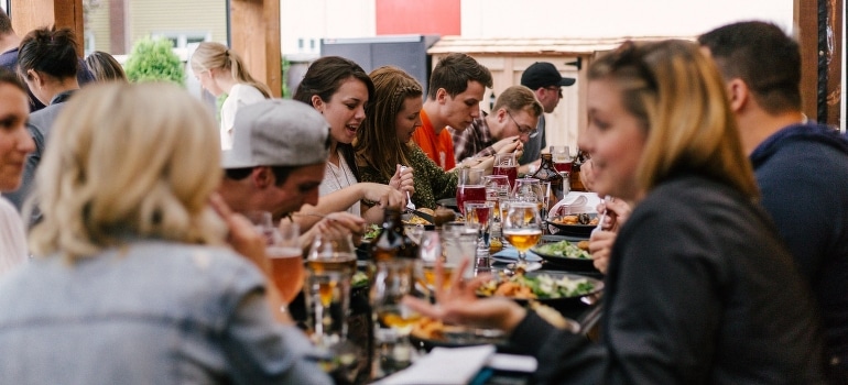 People sitting in front of the table eating and talking about Lighthouse Point for beginners