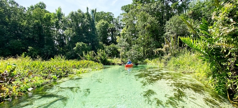 People riding a red kayak.