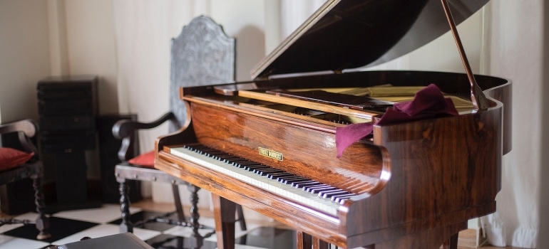 A brown grand piano with a chair