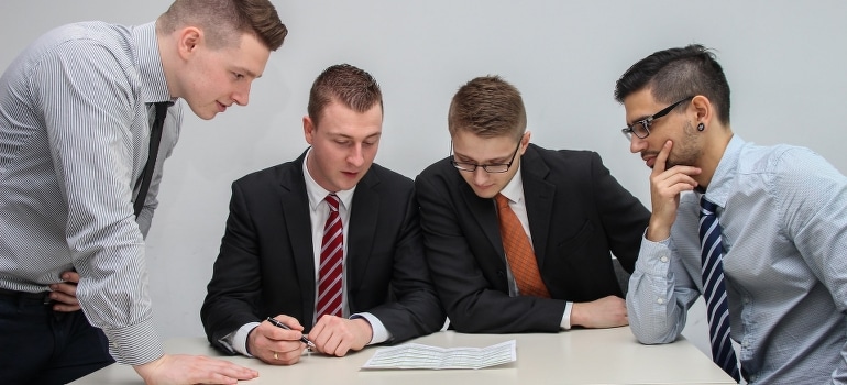 Four men looking at the paper on the table in one of the business-friendly cities in Florida