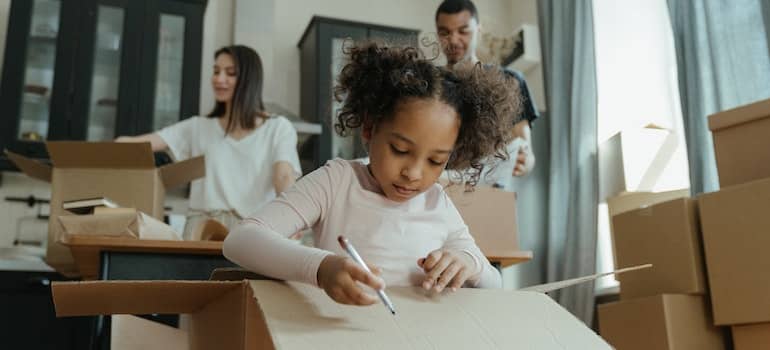 A girl labeling a moving box