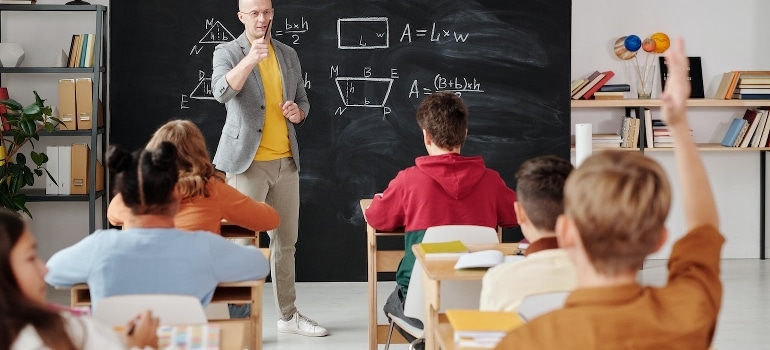 A teacher asks a question to the class.