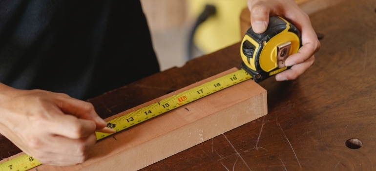 person using a yellow measure tape