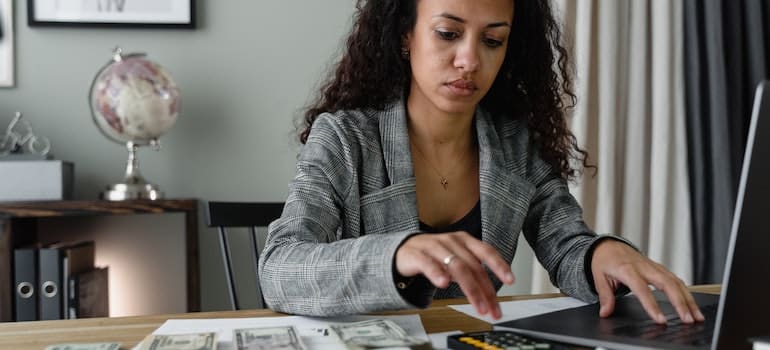 A woman calculating budget for a long distance move from Fort Lauderdale