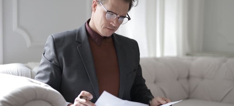 A person reading a contract in order to avoid moving scams in Florida