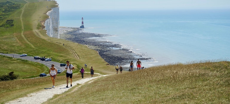 A group of people walking along the water 