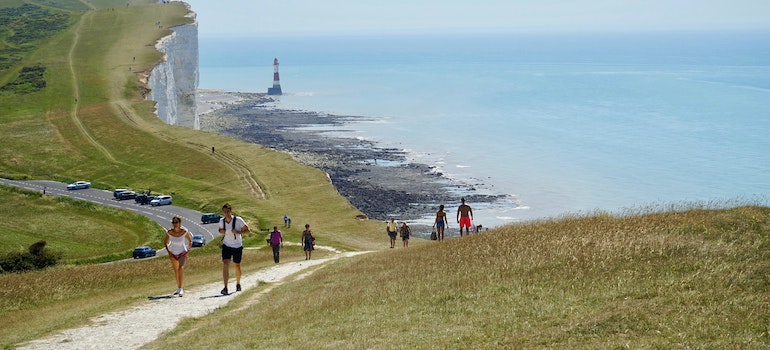 A group of people walking along the water