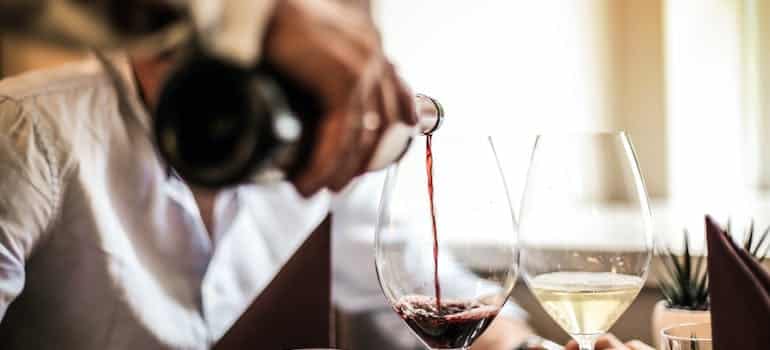 A person pouring a glass of red wine 