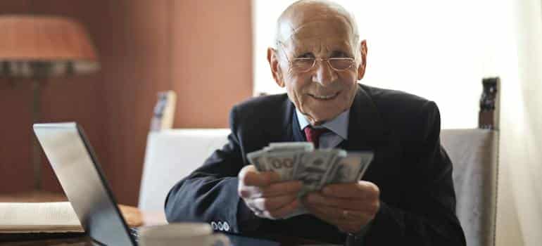 A senior holding dollar bills