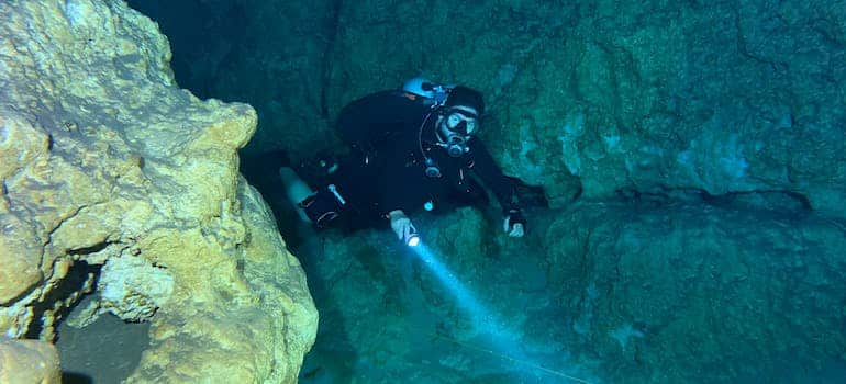 A person swimming in the cave, one of the sports to enjoy after relocating to Florida