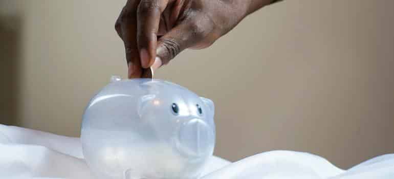 A person putting coin in a piggy bank 