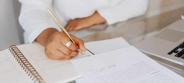 A woman writing on a white paper