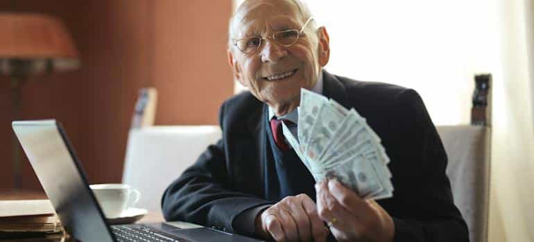 An older man holding dollar bills 