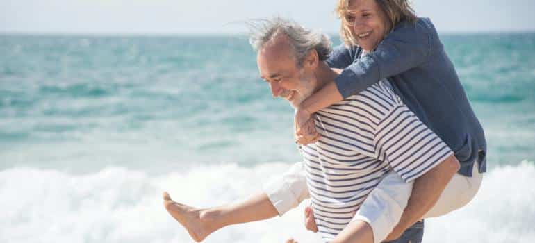 A couple on the beach thinking if they should retire in California or Florida