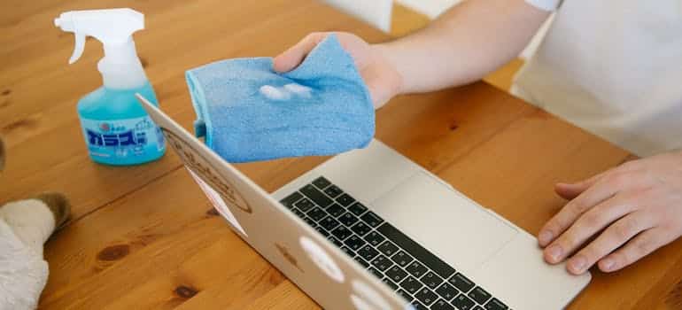 A person cleaning a laptop