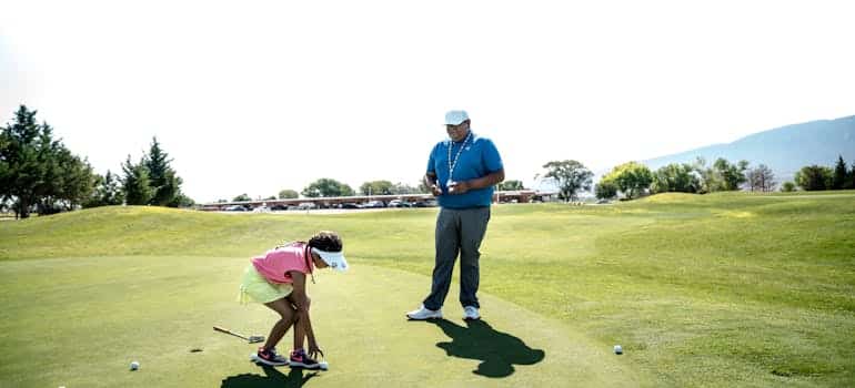 A kid learning how to play golf