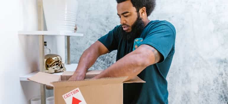 A mover packing a moving box