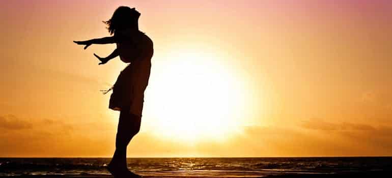 A woman on the beach looking at the sunshine