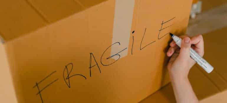 A person labeling a box fragile