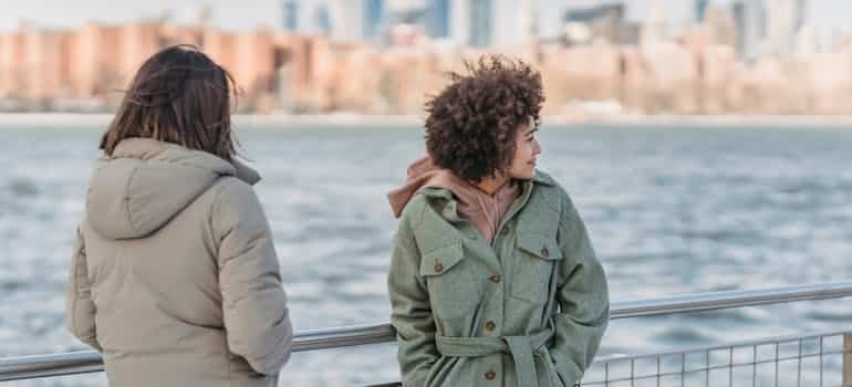 Two women next to the water 