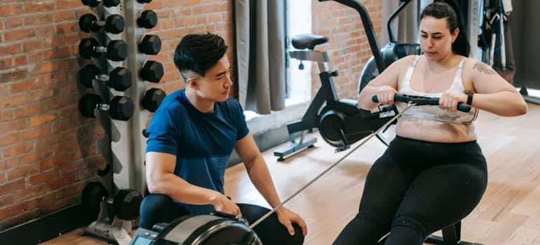 A woman exercising with a personal trainer which is one of the great businesses to start in Florida