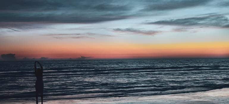 A person on the beach looking at the sunset