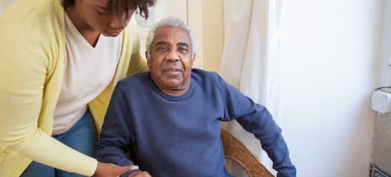 A woman assisting an elderly man 